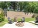 Beautiful backyard with a firepit, Adirondack chairs, and a retaining wall surrounded by mature trees at 121 Woodstaff Ave, Wake Forest, NC 27587