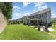 Expansive backyard with a well-manicured lawn, screened porch, firepit, and outdoor seating area at 121 Woodstaff Ave, Wake Forest, NC 27587