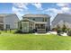 Spacious backyard with lush green grass, modern home exterior, hot tub and patio with outdoor seating at 121 Woodstaff Ave, Wake Forest, NC 27587