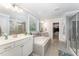 Bright bathroom with double vanity sinks, soaking tub, and glass enclosed shower at 121 Woodstaff Ave, Wake Forest, NC 27587