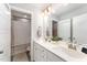Bright bathroom featuring double sinks, white cabinetry, and a shower with modern fixtures at 121 Woodstaff Ave, Wake Forest, NC 27587