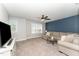 Cozy bonus room featuring a large sectional sofa, ceiling fan, and a wall-mounted television at 121 Woodstaff Ave, Wake Forest, NC 27587