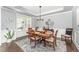 Dining room featuring a wooden table, six chairs, an elegant chandelier and lots of natural light at 121 Woodstaff Ave, Wake Forest, NC 27587