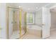 Primary bathroom with separate shower, soaking tub, tile surround, and garden window at 1221 Tartarian Trl, Apex, NC 27502