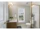 Bright bathroom with vanity sink, framed mirror, and tiled shower and flooring at 1221 Tartarian Trl, Apex, NC 27502