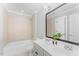 Modern bathroom featuring a double sink vanity, neutral tile, bathtub, and decorative plants at 1221 Tartarian Trl, Apex, NC 27502