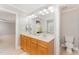 Bright bathroom with a double vanity, decorative mirror and fixtures, and a separate toilet room at 1221 Tartarian Trl, Apex, NC 27502