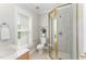 Bathroom featuring a tiled shower with a glass door, a window, and a vanity at 1221 Tartarian Trl, Apex, NC 27502