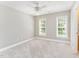 A bright bedroom has neutral paint, carpet, two windows, and an ensuite bathroom at 1221 Tartarian Trl, Apex, NC 27502