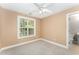 Neutral bedroom featuring a ceiling fan and a bright window view at 1221 Tartarian Trl, Apex, NC 27502