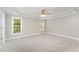 Large, well-lit bedroom features neutral carpet, tray ceiling and bright windows at 1221 Tartarian Trl, Apex, NC 27502