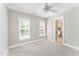 Carpeted bedroom featuring two windows, neutral paint, and an en-suite bathroom at 1221 Tartarian Trl, Apex, NC 27502