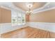 Inviting dining room with hardwood floors, wainscoting, and a stylish chandelier at 1221 Tartarian Trl, Apex, NC 27502