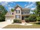 Charming brick two-story home featuring a two-car garage and inviting front yard at 1221 Tartarian Trl, Apex, NC 27502