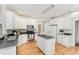 Modern kitchen boasts white cabinets, stainless steel appliances, island and neutral countertops at 1221 Tartarian Trl, Apex, NC 27502
