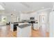 Open kitchen with white cabinets, stainless steel appliances, and dark countertops at 1221 Tartarian Trl, Apex, NC 27502