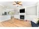Open concept living room with hardwood floors and fireplace and bar seating at 1221 Tartarian Trl, Apex, NC 27502
