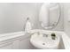Charming powder room with pedestal sink, oval mirror, wainscoting and neutral paint at 1221 Tartarian Trl, Apex, NC 27502