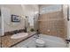 Bathroom featuring granite vanity, tub-shower combo, and neutral tile surround at 12508 Angel Falls Rd, Raleigh, NC 27614