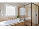 Bright bathroom boasts tiled tub with glass block window and glass enclosed shower at 12508 Angel Falls Rd, Raleigh, NC 27614