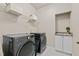 Convenient laundry room with modern gray LG washer and dryer, storage and wash sink at 12508 Angel Falls Rd, Raleigh, NC 27614
