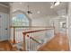 Bright living area with large arched windows, ceiling fan, and hardwood floors leading to carpeted space at 12508 Angel Falls Rd, Raleigh, NC 27614