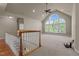 Spacious living room featuring large arched windows, ceiling fan, and plush carpeting at 12508 Angel Falls Rd, Raleigh, NC 27614