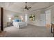 Spacious main bedroom featuring a tray ceiling, ceiling fan, and ample natural light from large windows at 12508 Angel Falls Rd, Raleigh, NC 27614