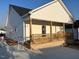 Rear view of a house with white siding and a covered porch with wood railing at 1303 Whitsett St, Burlington, NC 27217