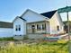 Lovely home with white siding and a welcoming front porch with a wooden railing at 1303 Whitsett St, Burlington, NC 27217