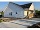 Rear view of a house with white siding and a concrete patio at 1303 Whitsett St, Burlington, NC 27217