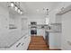 Modern kitchen with stainless appliances, granite counters, white cabinets, and wood-look flooring at 1303 Whitsett St, Burlington, NC 27217