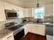Modern kitchen featuring white cabinets, granite countertops, and stainless steel appliances at 1303 Whitsett St, Burlington, NC 27217