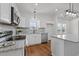 Well-lit kitchen with stainless appliances, granite counters, white cabinets, and breakfast bar seating at 1303 Whitsett St, Burlington, NC 27217