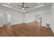 Bright living room with hardwood floors, ceiling fan, and an open layout to the kitchen and bathroom at 1303 Whitsett St, Burlington, NC 27217