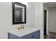 Stylish bathroom featuring a vanity with marble countertop, blue cabinets, and black framed mirror, exuding modern elegance at 1314 Hudson Ave, Durham, NC 27705