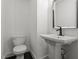 A half bathroom features a modern sink and toilet, enhanced by minimalist decor and neutral tones at 1314 Hudson Ave, Durham, NC 27705