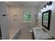 Bathroom features tub, shower, white tile surround, marble-look countertop, and bronze hardware at 1314 Hudson Ave, Durham, NC 27705