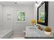 Modern bathroom featuring white tile, marble counters, and a large framed mirror, offering a clean and elegant design at 1314 Hudson Ave, Durham, NC 27705