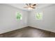 Bright bedroom featuring hardwood floors, neutral walls, a ceiling fan, and two windows allowing ample natural light at 1314 Hudson Ave, Durham, NC 27705