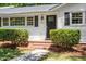 Charming home entrance with a black door, brick steps, and manicured hedges at 1314 Hudson Ave, Durham, NC 27705