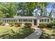 Charming single-story home with white siding, a black front door, and mature landscaping at 1314 Hudson Ave, Durham, NC 27705
