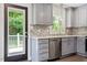 A modern kitchen showcases gray cabinets, stainless steel appliances, and door to an outdoor view at 1314 Hudson Ave, Durham, NC 27705