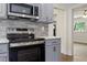 A kitchen features stainless steel appliances, gray cabinets and an open view into another room at 1314 Hudson Ave, Durham, NC 27705