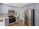 A modern kitchen includes stainless steel appliances, gray cabinets, and a refrigerator with wood flooring at 1314 Hudson Ave, Durham, NC 27705