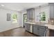 A spacious kitchen features gray cabinets, stainless steel appliances, and natural light from windows at 1314 Hudson Ave, Durham, NC 27705