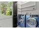 Well-organized laundry room featuring blue Samsung washer and dryer with built-in shelving for ample storage at 1314 Hudson Ave, Durham, NC 27705