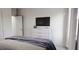 Bright bedroom featuring a sleek white dresser with a TV and natural light streaming in from a side window at 136 Fairport Ln, Apex, NC 27539