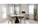 Dining room with a round table, modern chairs, large windows and interior decorations at 136 Fairport Ln, Apex, NC 27539