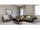 Cozy living room featuring a comfortable sofa, modern chairs, and ample natural light from large windows at 136 Fairport Ln, Apex, NC 27539